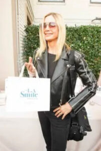 Mira Sorvino holding an LA Smile bag