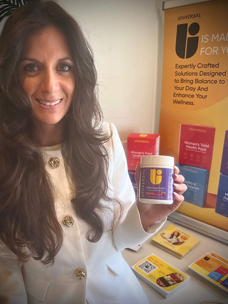 Woman holding up jar of Universal Nutrition Ashwagandha