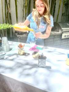 Woman pouring drinks from Good Juju