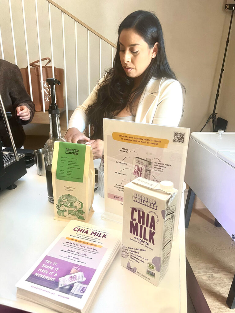 Woman in front of Seeds of Wellness Chai Milk display