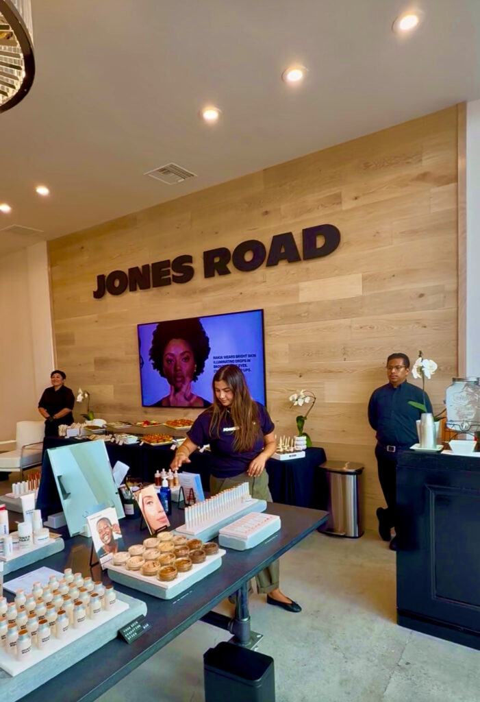 Jones Road logo on wall while staff prepares for the opening of their Santa Monica store