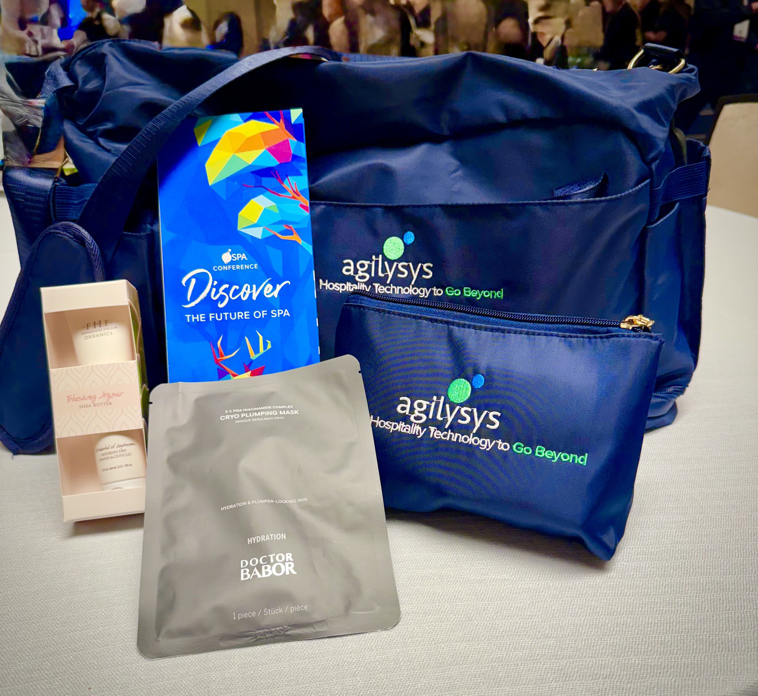 ISPA 2026 Travel bag featuring Agilysys Hospitality Technology to Go Beyond Doctor Babor Mask , FHF Farm House Shea Butter, Handful of Daydreams