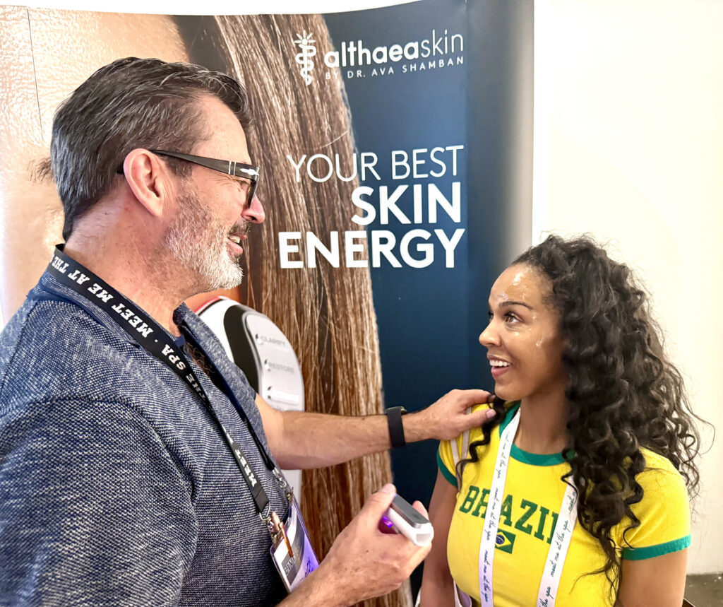 Man taking test on woman wearing Brazil shirt at the AlthaeaSkin by Dr Ava Shamban at Live Love Spa LA 2025