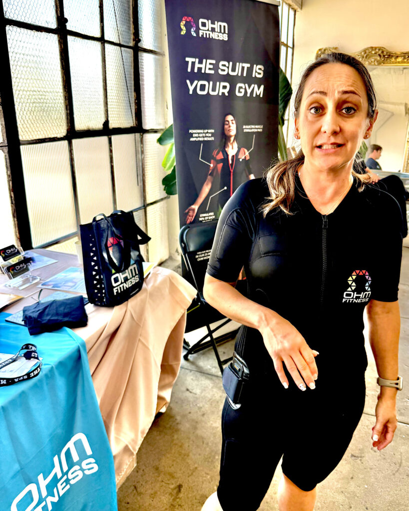 Woman at OHM Fitness booth where the Suit is your Gym at Live Love Spa LA 2025