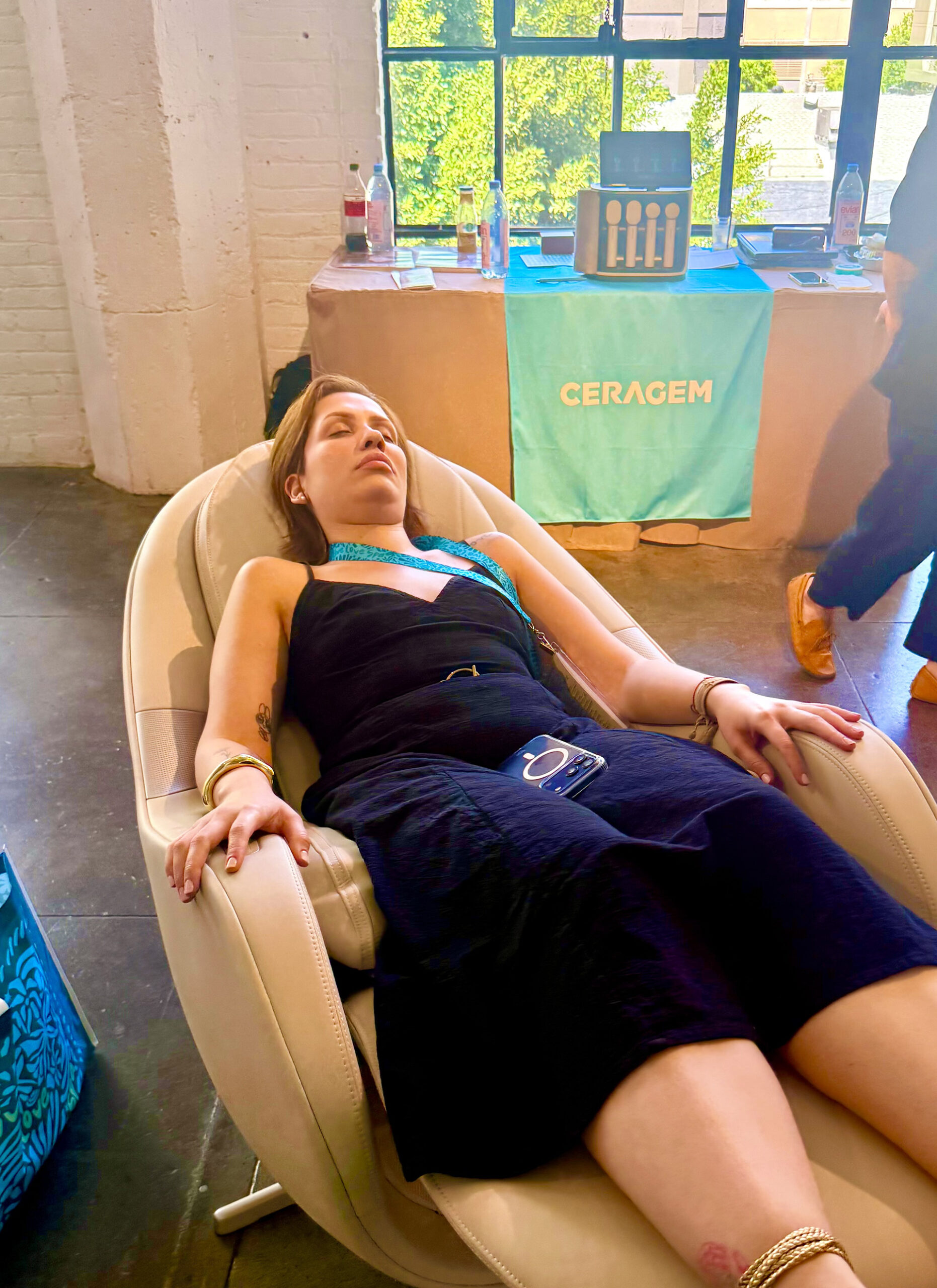 Ceragem Woman on relaxation chair in front of the Ceragem booth at Live Love Spa