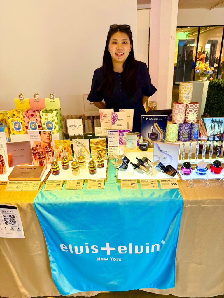 Woman in front of display at Elvis + Elvin New York booth at Live Love Spa