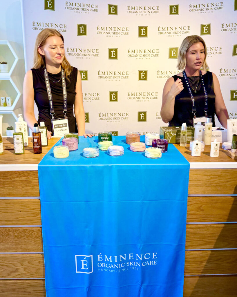 Two women at the Eminence Organic Skin Care booth at Live Love Spa
