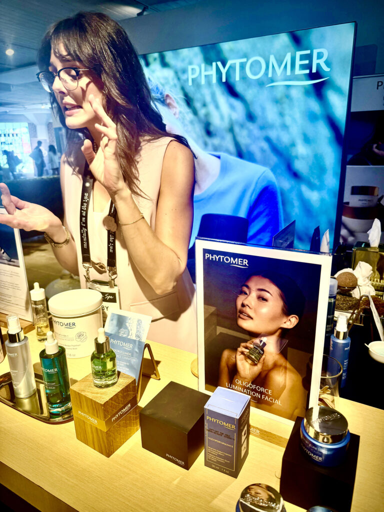 Woman in front of product display at Phytomer booth at Live Love Spa