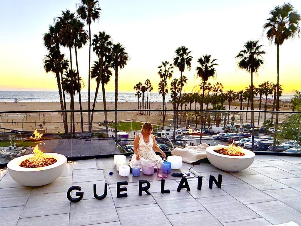 Woman performing Yoga in front of the Guerlain sign at the balcony of the Regent Santa Monica Beaches