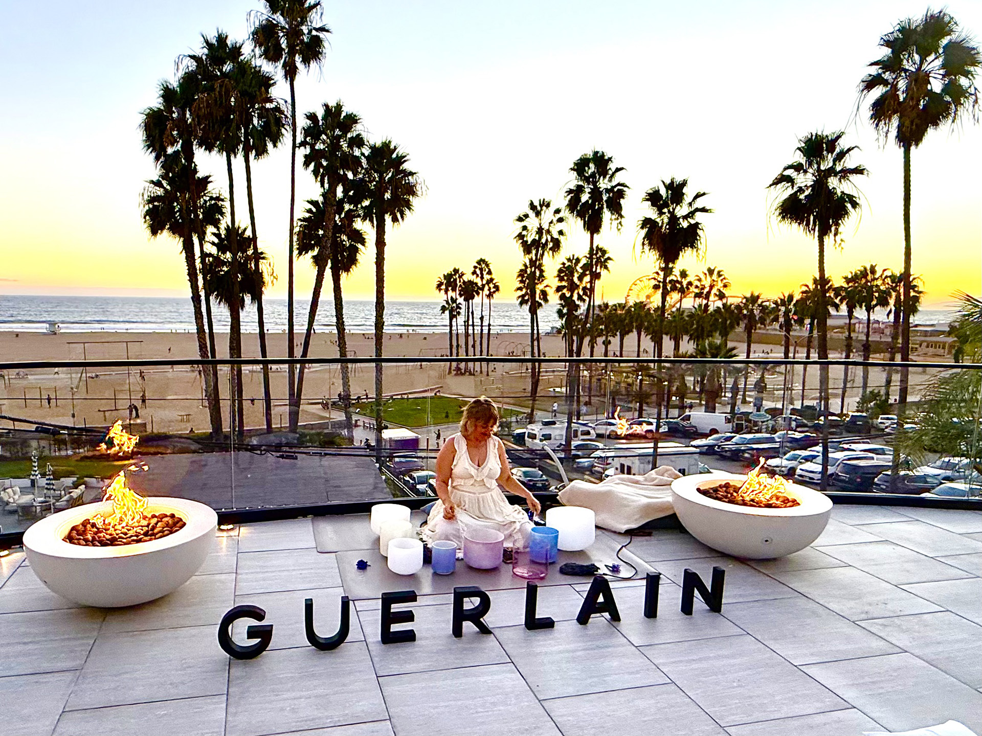Woman performing Yoga in front of the Guerlain sign at the balcony of the Regent Santa Monica Beaches