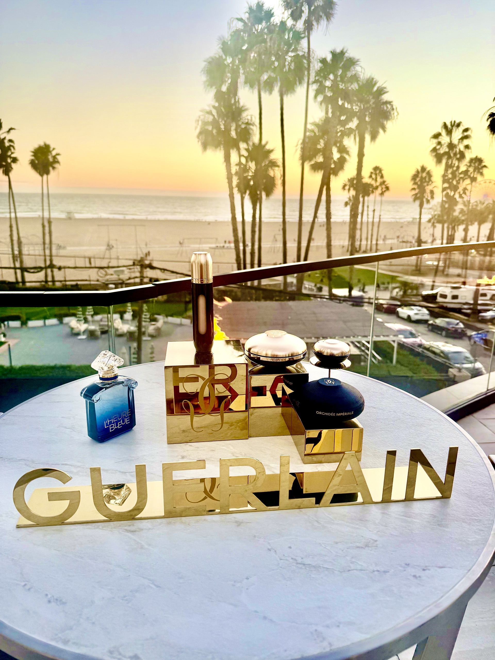 Guerlain Paris Serum Collection Angled view of products from Guerlain Paris with a view of the Santa Monica beaches